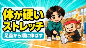 バレーで体が硬い選手が床に座って足を伸ばすストレッチを、コーチが足首を指差して説明している